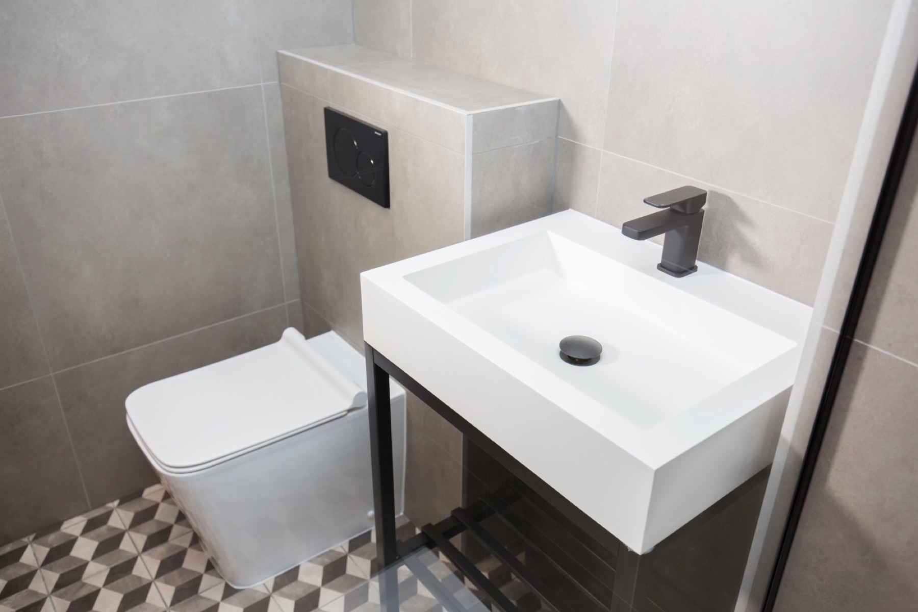 The finished grey bathroom with a 3D-cube pattern floor